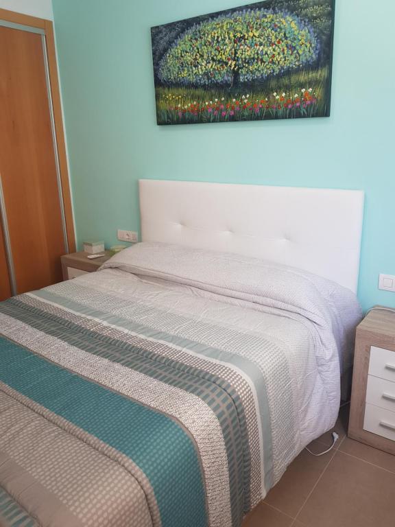 a bedroom with a bed with a painting on the wall at Apartamento Blau Mar in Piles