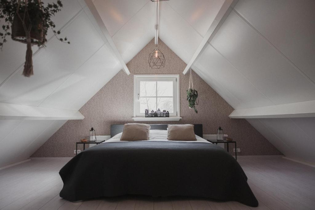 a bedroom with a large bed in a attic at B&B Landelijke Rust in Lutjewinkel
