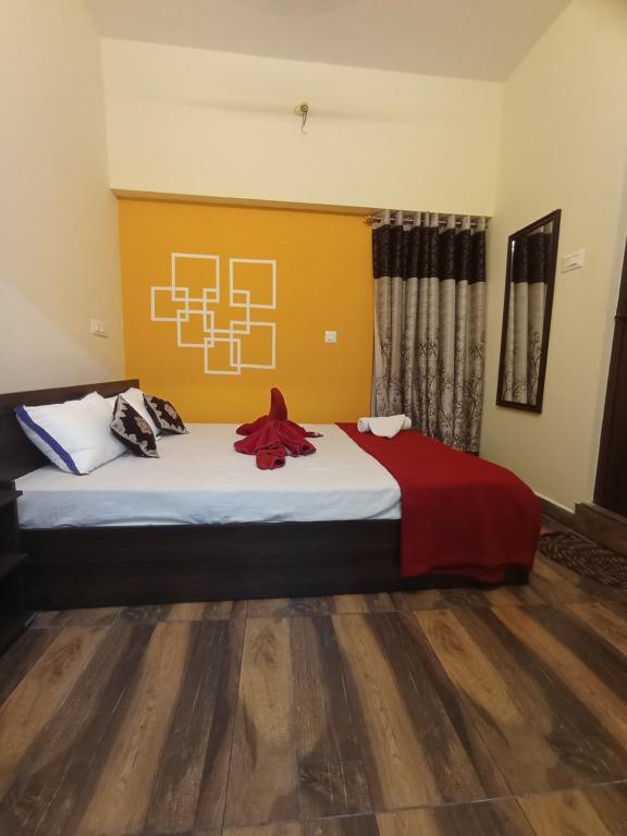 ティルチラーパッリにあるArangan kudil Family Stayのベッドルーム1室(赤毛布付きの大型ベッド1台付)