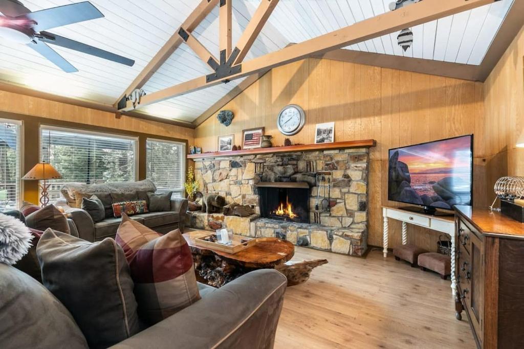 uma sala de estar com um sofá e uma lareira de pedra em Classic 3BD Tahoe Cabin with Hot Tub em Carnelian Bay