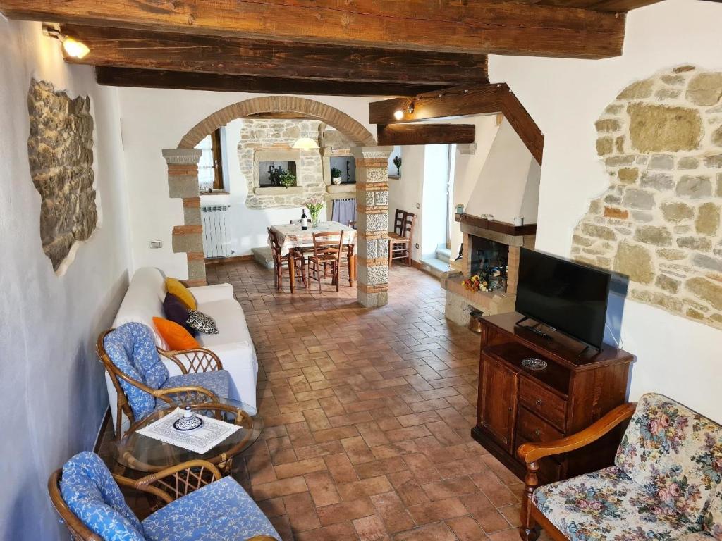 ein Wohnzimmer mit einem Sofa und einem TV in der Unterkunft Studio für 7 Personen ca 90 qm in Pratovecchio, Toskana Provinz Arezzo in Pratovecchio