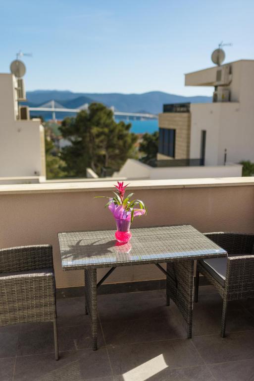 a table with a vase with flowers on a balcony at Providenca in Komarna