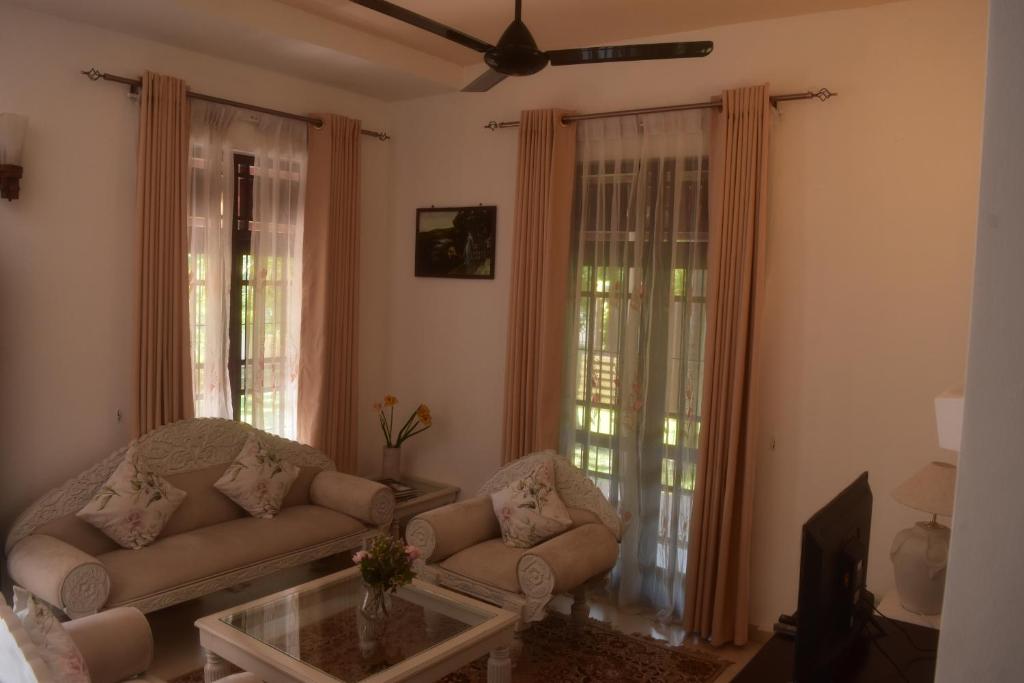 uma sala de estar com um sofá e uma mesa de centro em Casa Winnie em Kelaniya