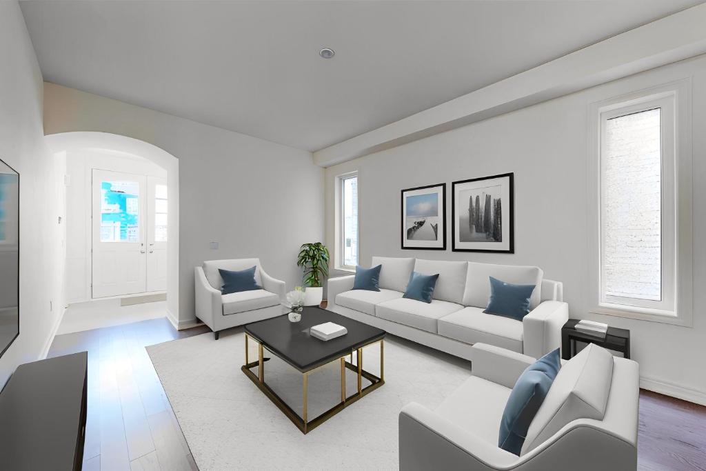 a white living room with a couch and a table at 4-Bedroom Serenity Retreat - Comfort & Style in Brampton