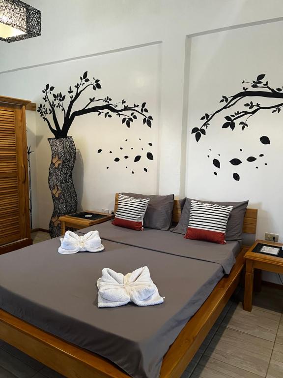 ein Schlafzimmer mit einem Bett mit zwei Handtüchern darauf in der Unterkunft SASCHAS PLACE in Siquijor