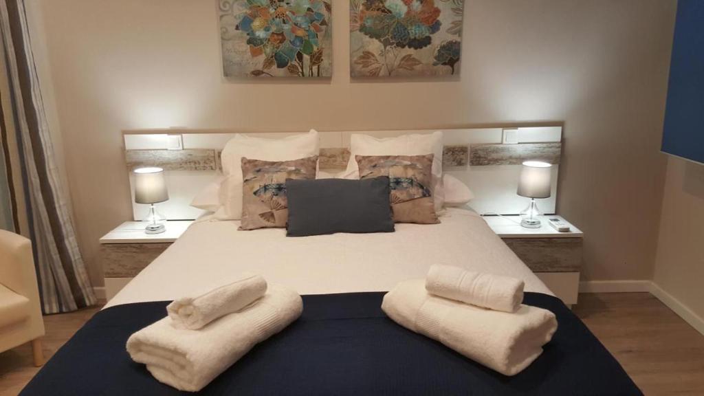 1 dormitorio con 1 cama blanca grande y 2 almohadas en San Nicolás II, en Toledo