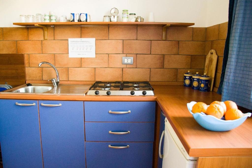 uma cozinha com armários azuis e uma taça de fruta em Ferienwohnung für 2 Personen ca 40 qm in Cattolica Eraclea, Sizilien Provinz Agrigent - b55719 em Cattolica Eraclea