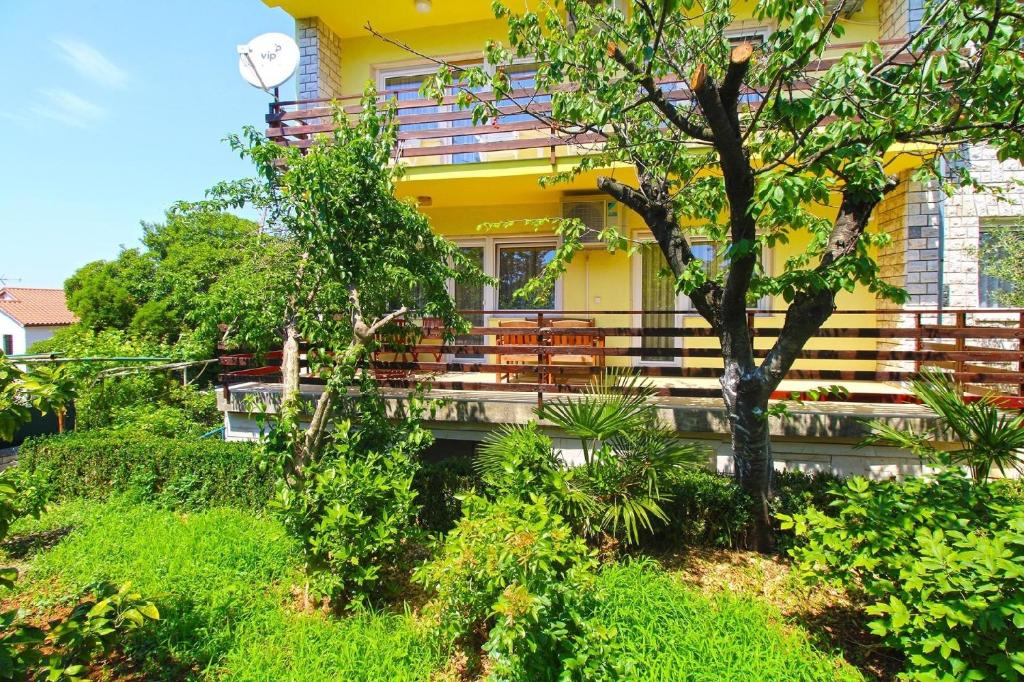Maison jaune avec balcon et bancs dans l'établissement Ferienwohnung für 6 Personen ca 110 qm in Banjole, Istrien Istrische Riviera, à Banjole