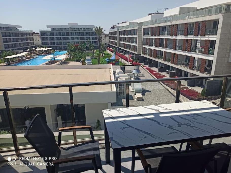 a balcony with a table and chairs and a pool at Comfy, Luxury Flat for All Ages in Iskele