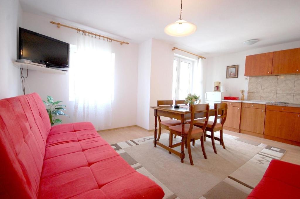 - un salon avec un canapé rouge et une table dans l'établissement Ferienwohnung für 4 Personen ca 37 qm in Njivice, Kvarner Bucht Krk - b58789, à Njivice