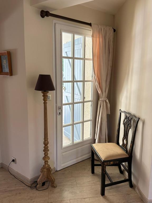 a chair and a lamp in front of a window at Central Valbonne Villa in Valbonne