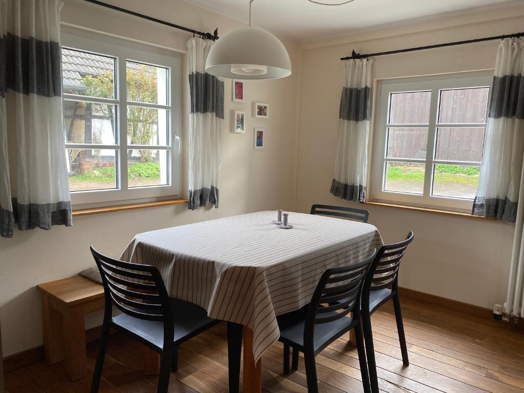 a dining room with a table and chairs and windows at Ferienhaus Wietsche in Burscheid