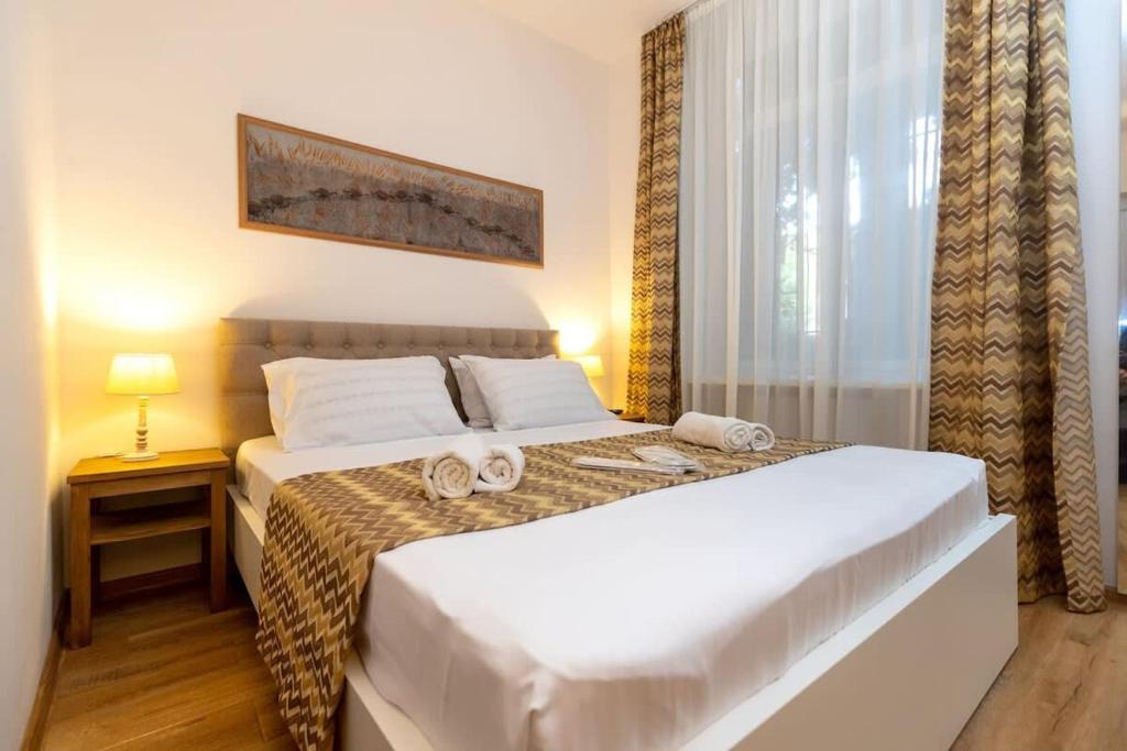 - une chambre avec un lit et des serviettes dans l'établissement Wehost Liberty Square Apartments, à Tbilissi