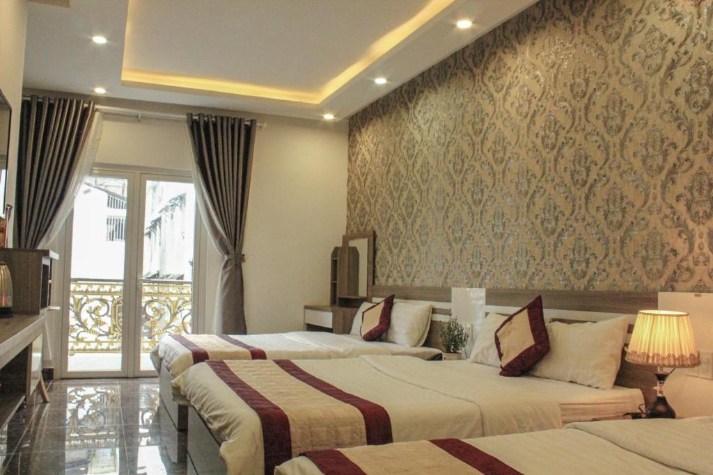 a hotel room with two beds and a balcony at Tiến Anhh 1 in Da Lat