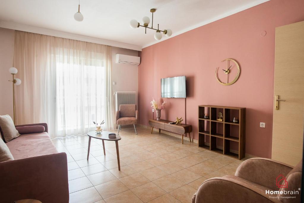 Una sala de estar con un sofá y un reloj en la pared. en AXDHOME venizelou project by homebrain, en Alexandroupoli