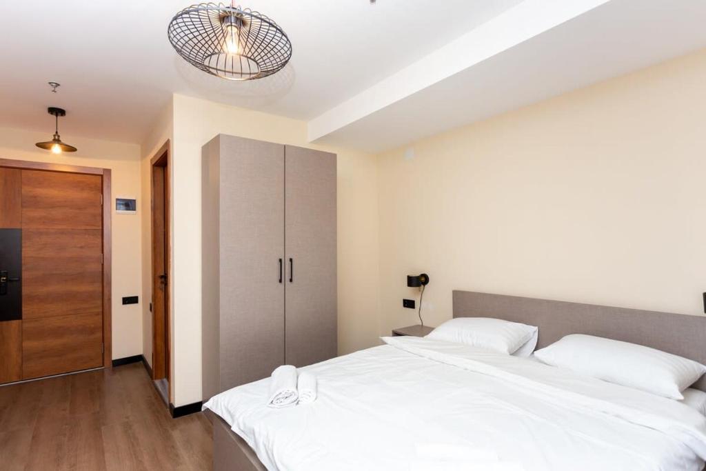 sypialnia z 2 białymi łóżkami i szafą w obiekcie Apartment in Marshall Gudauri Project w mieście Gudauri