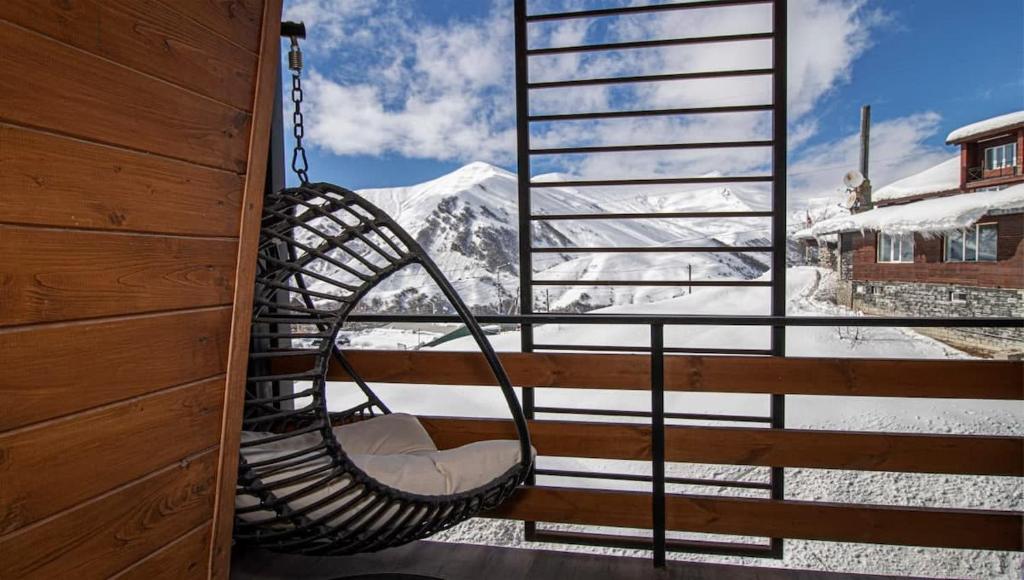a porch swing with a view of a snow covered mountain at Stylish Studio Apartment with balcony in Gudauri