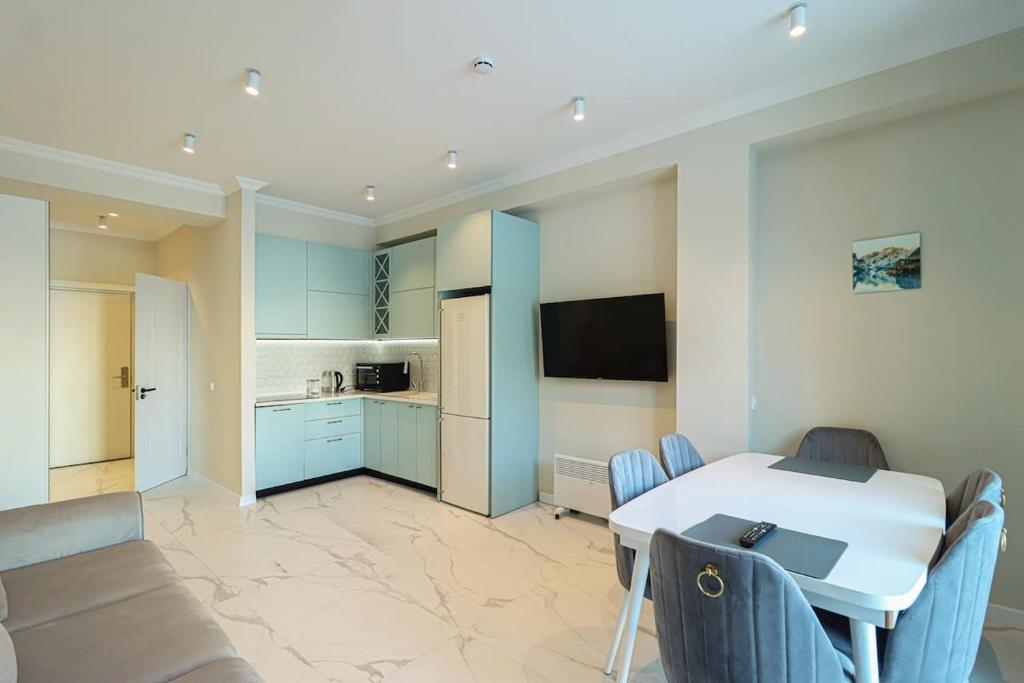 Il comprend une cuisine et un salon avec une table et des chaises. dans l'établissement Apartment Alpic 204- Near Ski Lift - By Wehost, à Goudaouri