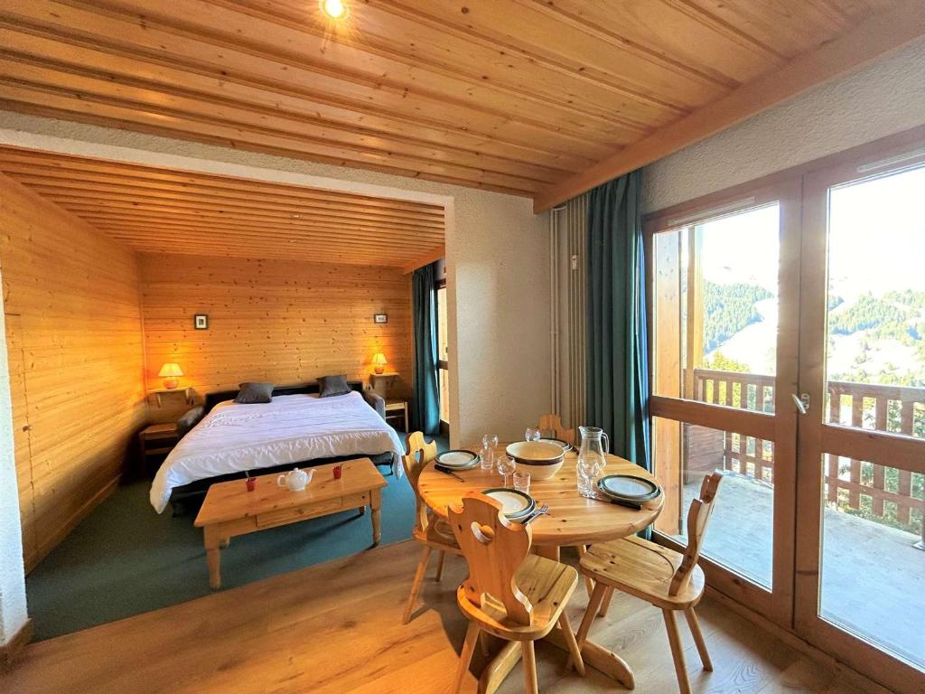 - une chambre avec un lit, une table et un lit dans l'établissement Apt 2 pièces pour 4 pers, à 150m des pistes, Méribel - FR-1-180-68, à Méribel