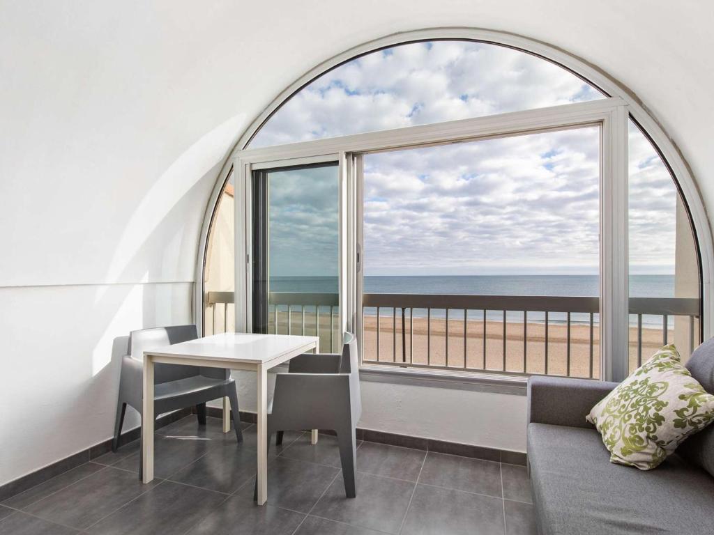 - un salon avec une table et une vue sur l'océan dans l'établissement Duplex 3 pièces à Marseillan, 2 chambres, 6 pers, proche plage - FR-1-326-739, à Marseillan