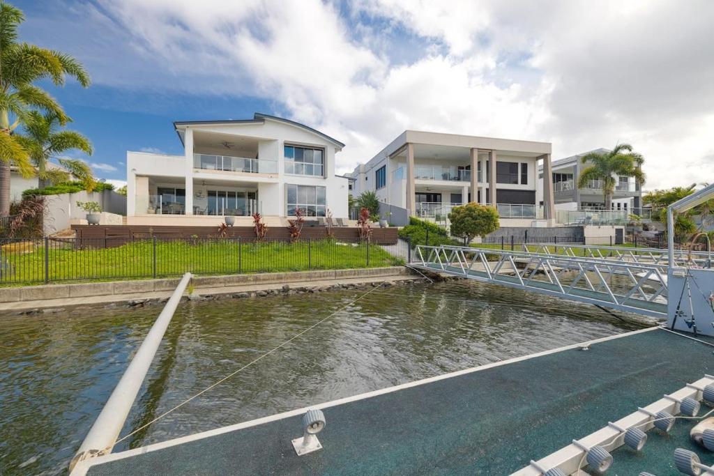 a house with a pond in front of a house at 3BR Serene Waterfront Retreat with pool & dock in Gold Coast