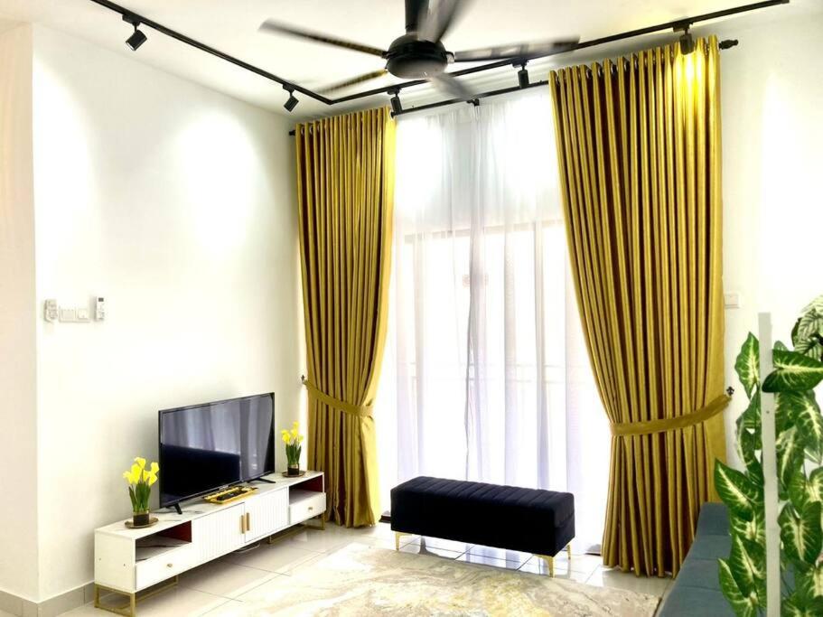 a living room with yellow curtains and a tv at AYMAR Homestay, Youth City. in Nilai