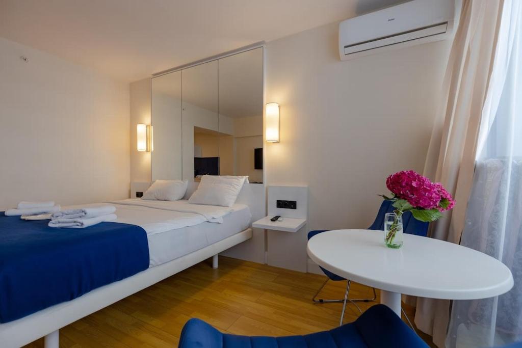 a bedroom with a bed and a table and a mirror at Stylish Studio in New Batumi in Batumi