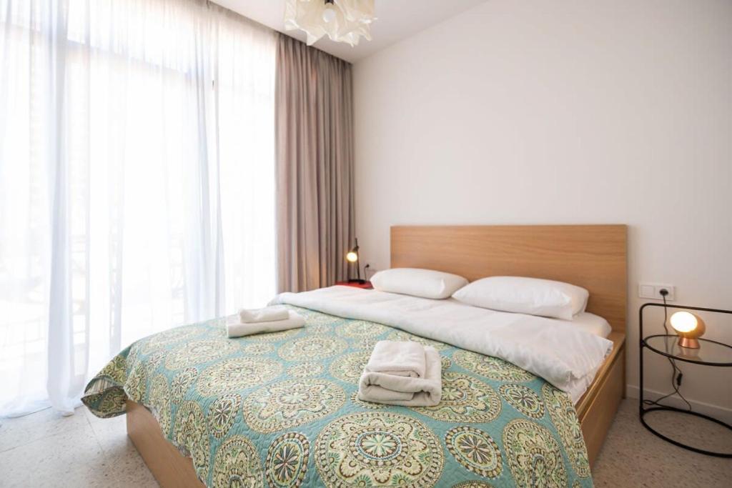 a bedroom with a large bed with two towels on it at Cozy 1BR Apt Old Batumi in Batumi