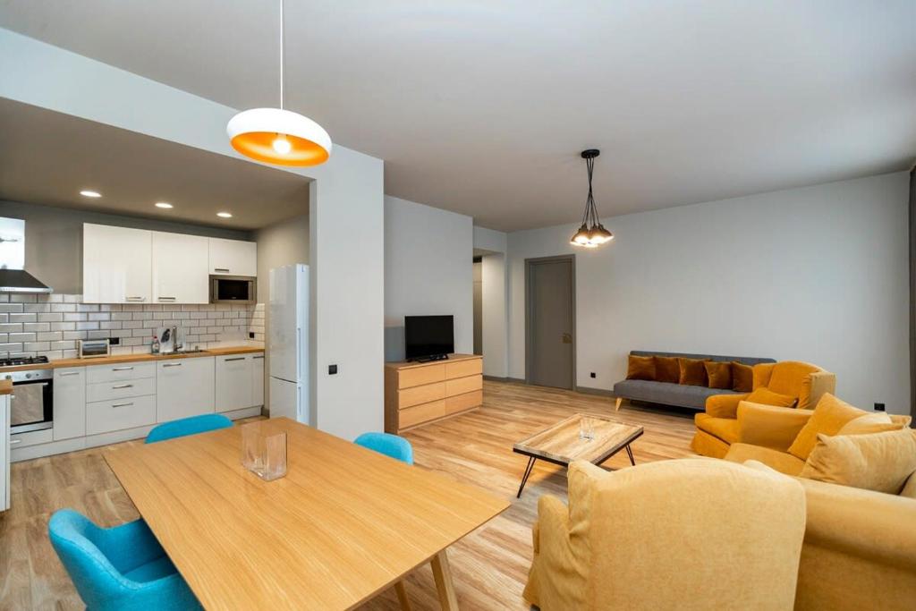 a kitchen and a living room with a table and chairs at Stylish newly renovated 1 BR Apt on the modern Abashidze street in Tbilisi City