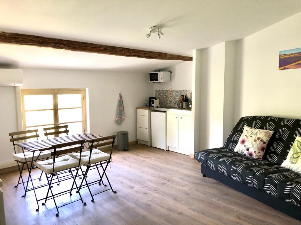 uma sala de estar com uma mesa e um sofá em Logement neuf et climatisé, au coeur du village em Saint-Didier