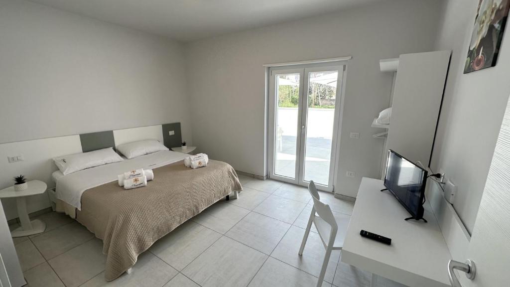 特羅佩阿的住宿－Il Narciso Residence，一间卧室配有一张床、一台电视和一张桌子