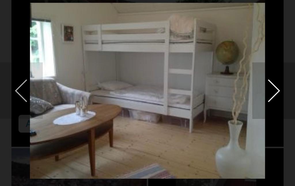 Cette chambre comprend 2 lits superposés et une table. dans l'établissement Lillstuga Badholmen, à Fjällbacka