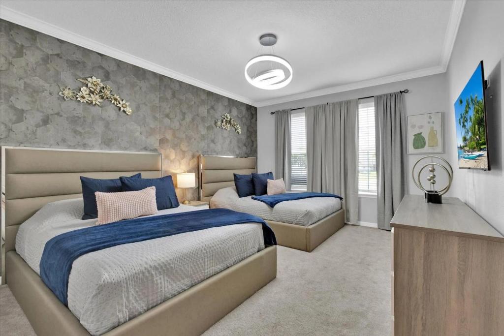 1 dormitorio con 2 camas y TV. en Enchanted Villa, en Orlando