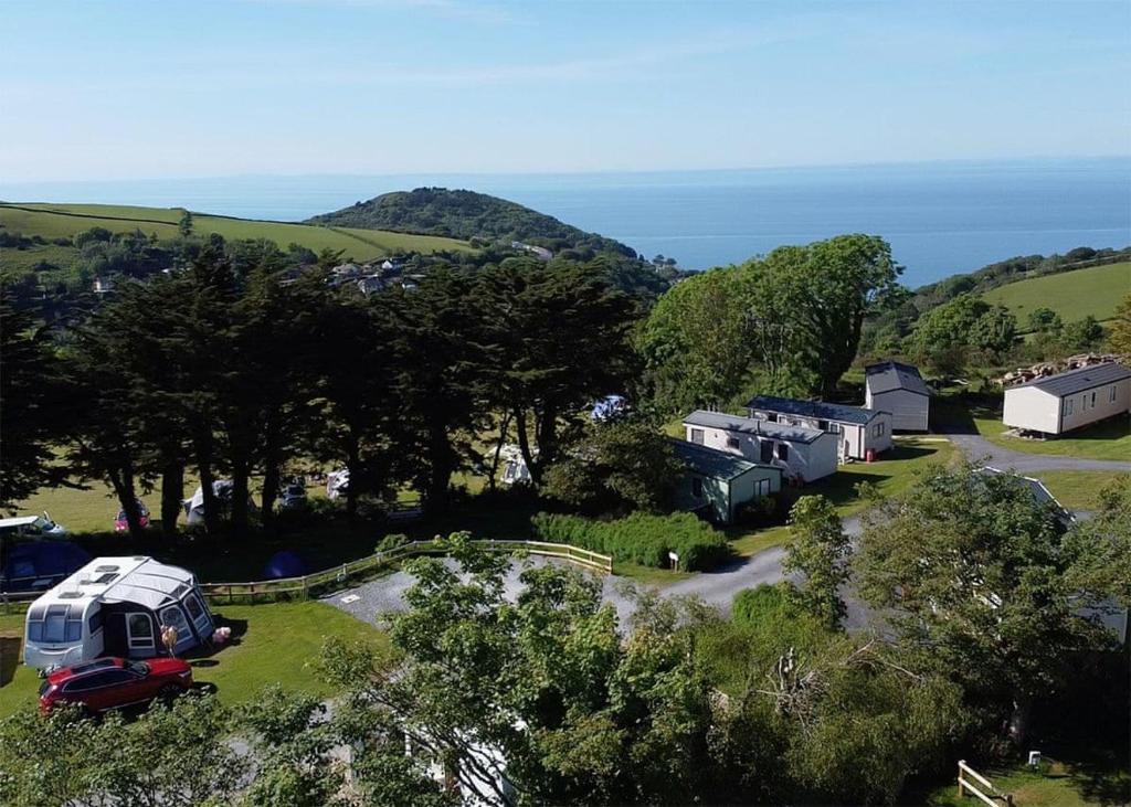 a group of rvs parked in a field with the ocean at Lynmouth Holiday Retreat in Lynton