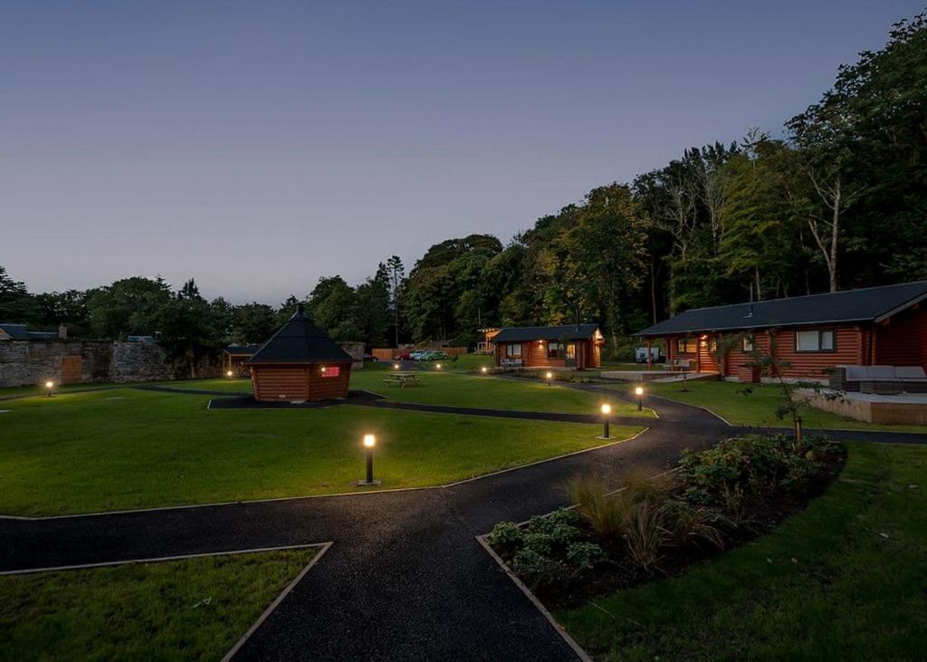 un patio con lodges y luces por la noche en Gadgirth Estate Lodges en Annbank