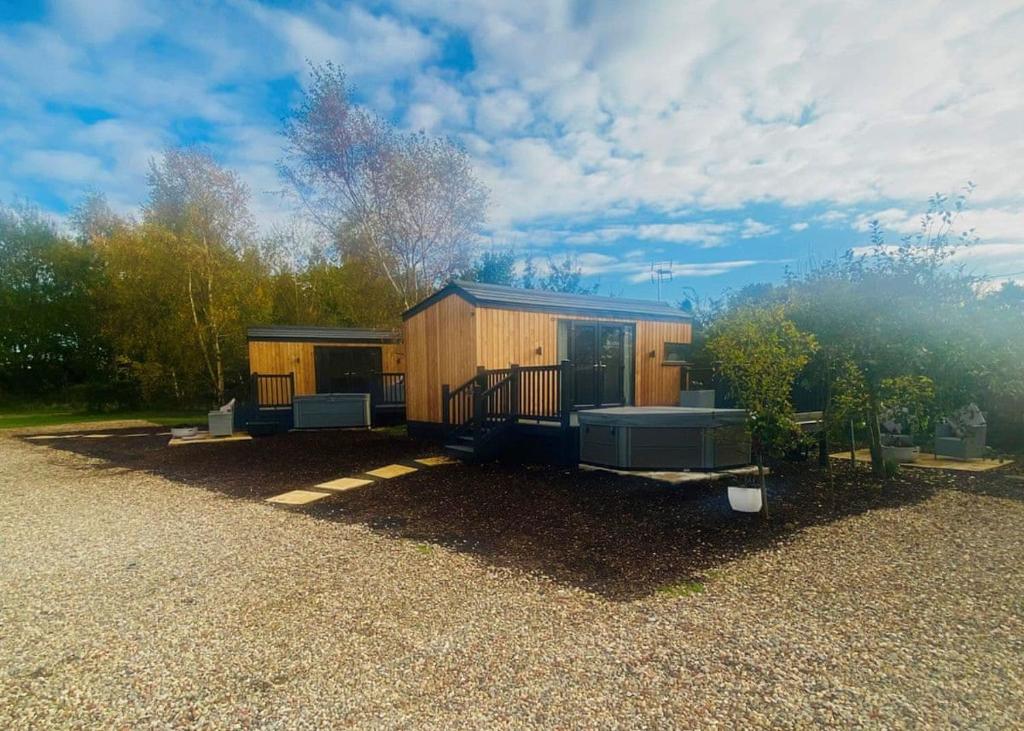 a small cabin with a porch on a gravel yard at Watermill Leisure Park 