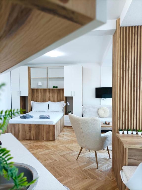 a bedroom with a bed and a desk and a chair at Apartman Rajska Banja in Vrnjačka Banja