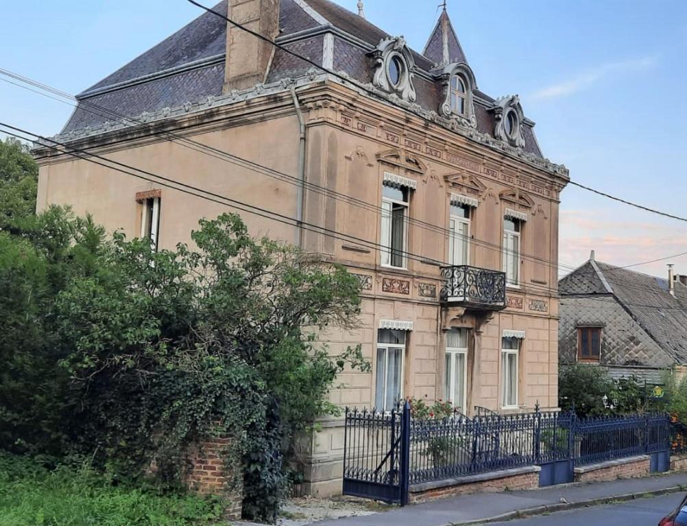 een oud huis met een hek ervoor bij Le Petit Chateau in Saint-Michel