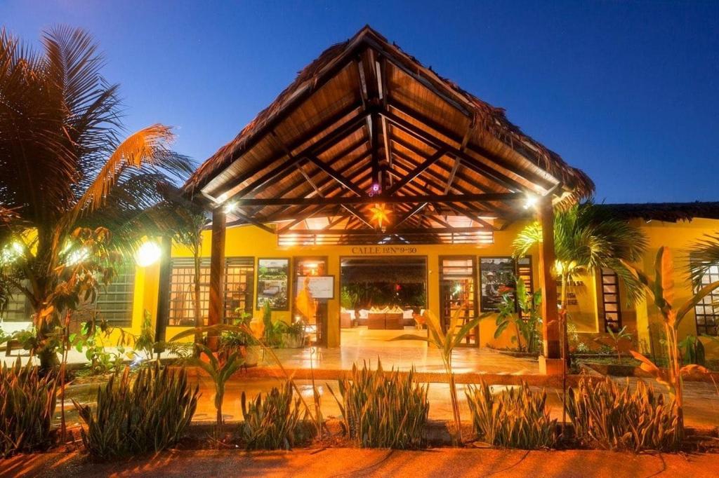 a yellow building with palm trees in front of it at Hotel Amazon Bed And Breakfast in Leticia