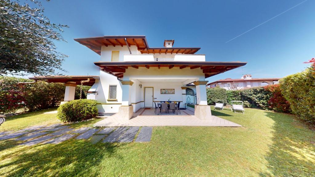 a small white house with a roof on a lawn at Villa Platani con piscina-BGL in Manerba del Garda