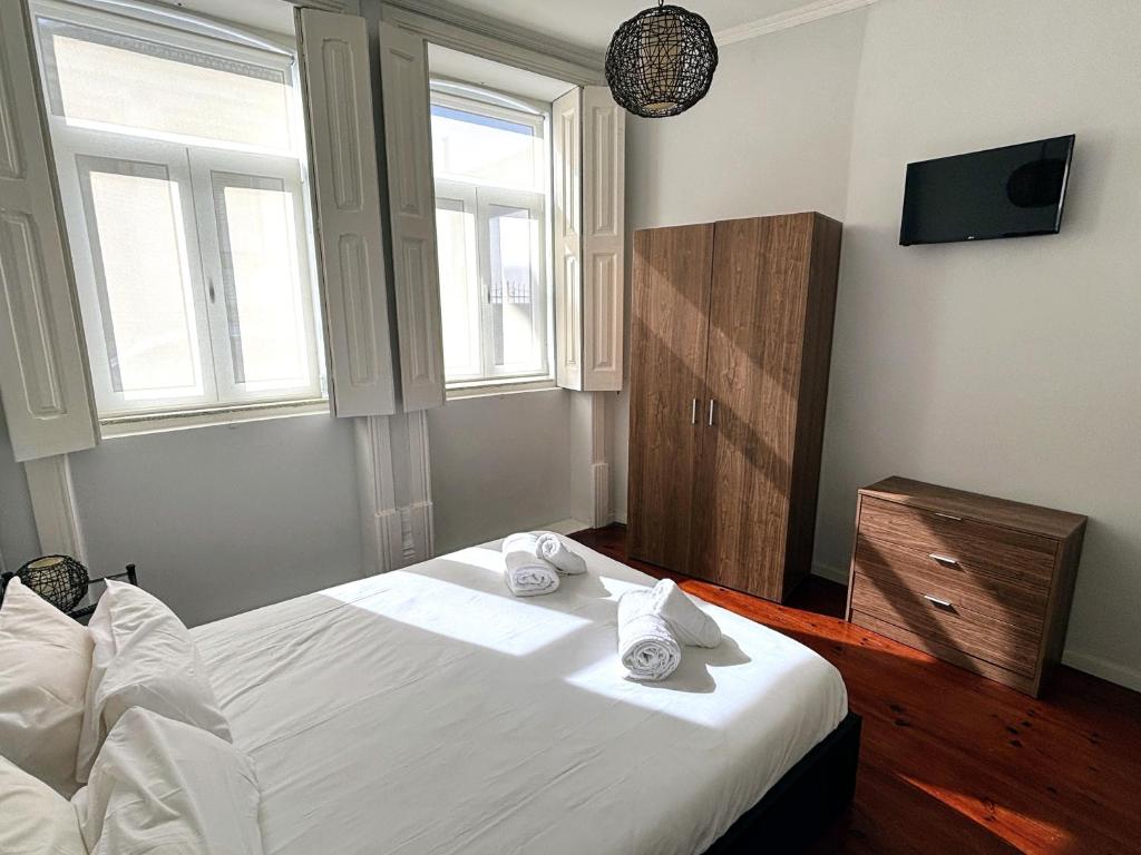 um quarto com uma cama branca e toalhas em Covelo Apartment no Porto