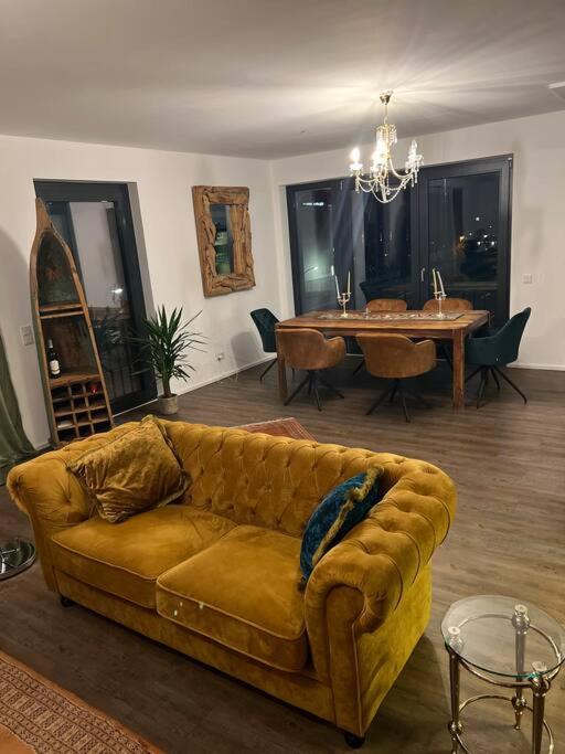 ein Wohnzimmer mit einem Sofa und einem Esstisch in der Unterkunft Luxuriöse Ferienwohnung mit Sauna und Whirlpool in Köln