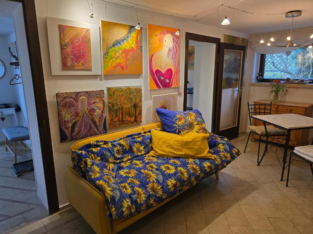 a couch in a room with paintings on the wall at Ferienwohnungen Thomsen Bergdorf Pobershau in Marienberg