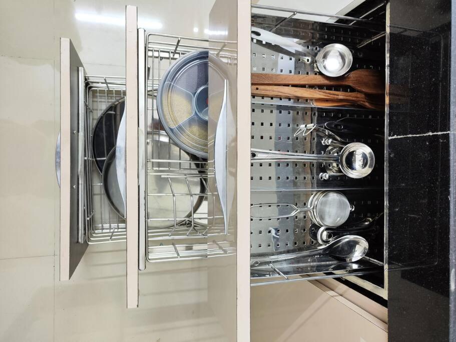 a kitchen with a glass cabinet filled with utensils at 2BHK AC Service Apartment 103 in Pune