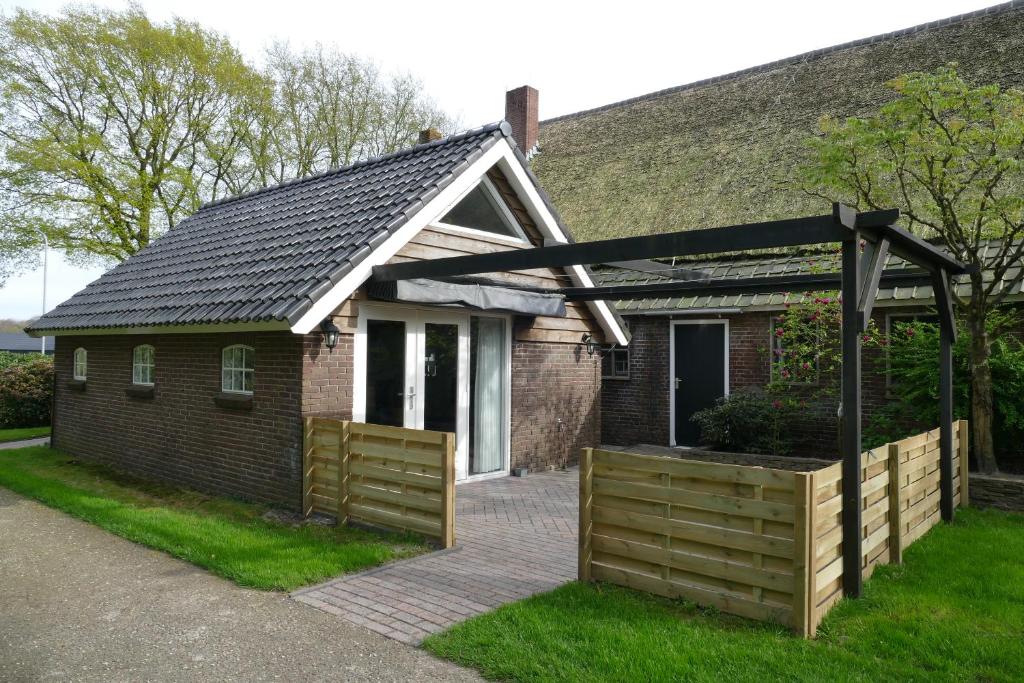 uma casa com uma cerca de madeira em frente em 't Stookhok Gasselte em Gasselte