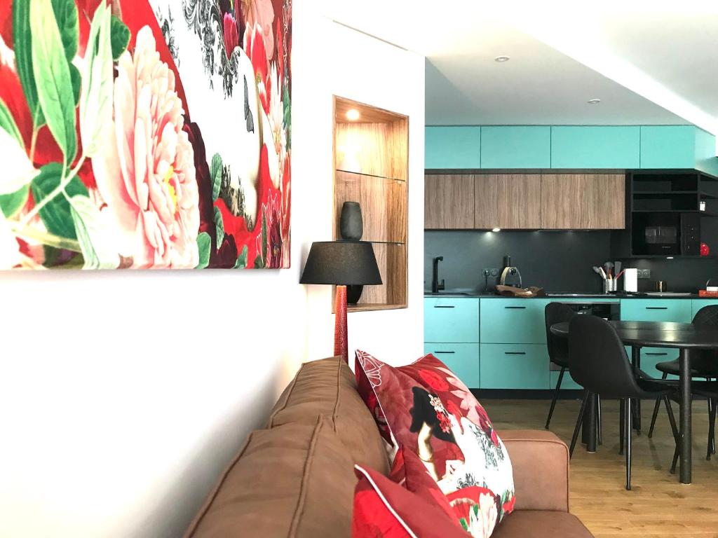 un salon avec un canapé et une cuisine dans l'établissement LE SORNIN - Garage - Clim - Hypercentre - Terrasse, à Vichy