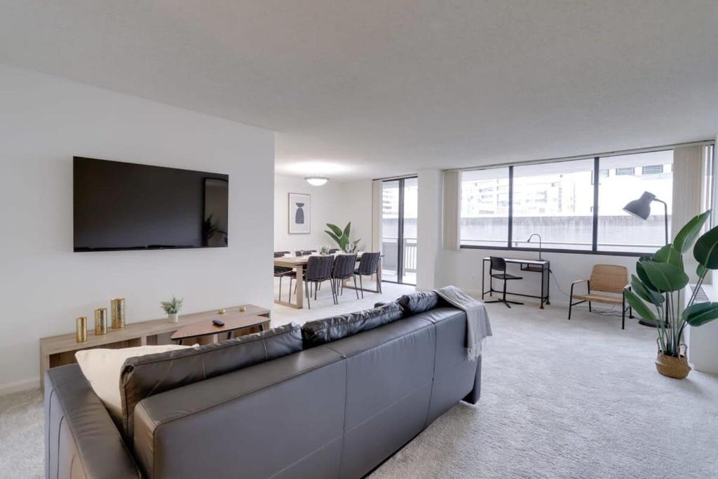 uma sala de estar com um sofá grande e uma televisão em Condo Near to Metro Station at Crystal city em Arlington