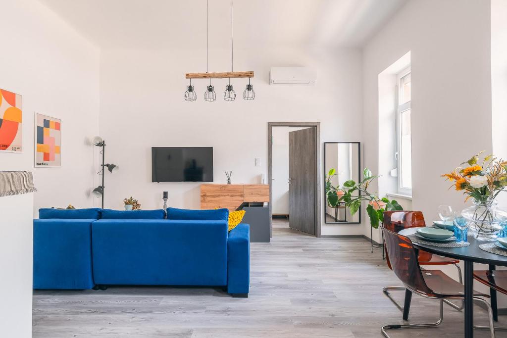 uma sala de estar com um sofá azul e uma mesa em Heroes' Square Stay em Budapeste