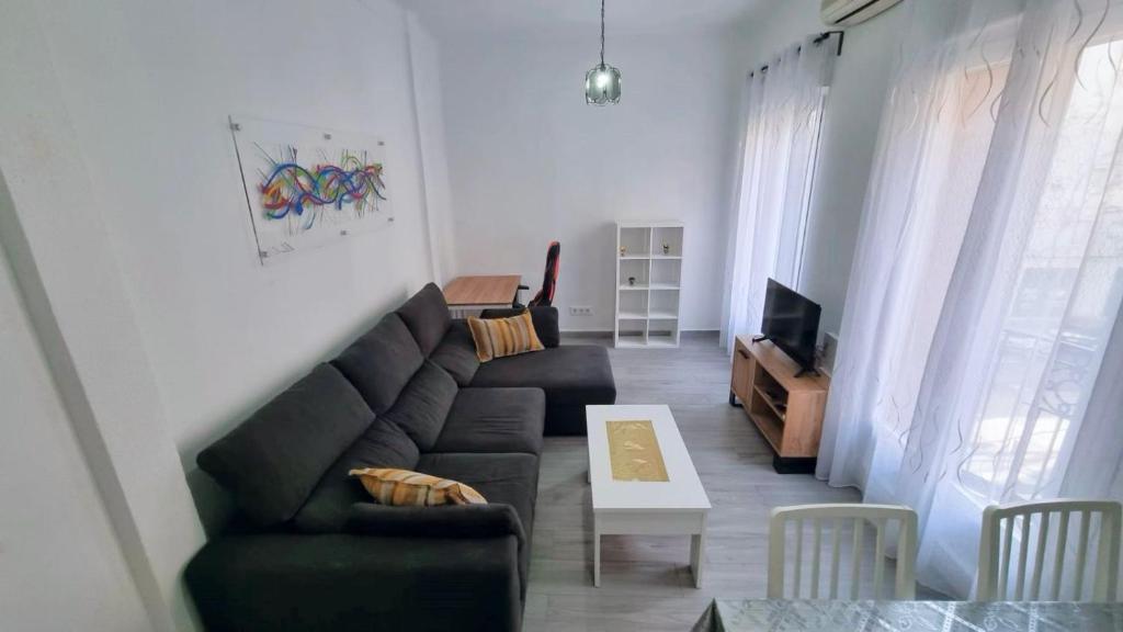 ein Wohnzimmer mit einem Sofa und einem Tisch in der Unterkunft Renovado apartamento en Delicias by beBalmy in Madrid