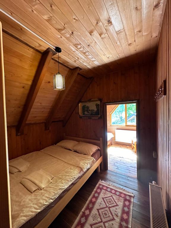a bedroom with a bed in a wooden cabin at Guest House Rilindja Valbone in Valbonë
